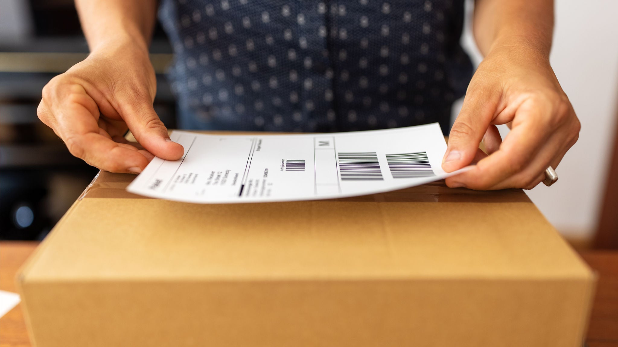 photo-woman-sticking-postage-label-on-parcel-box