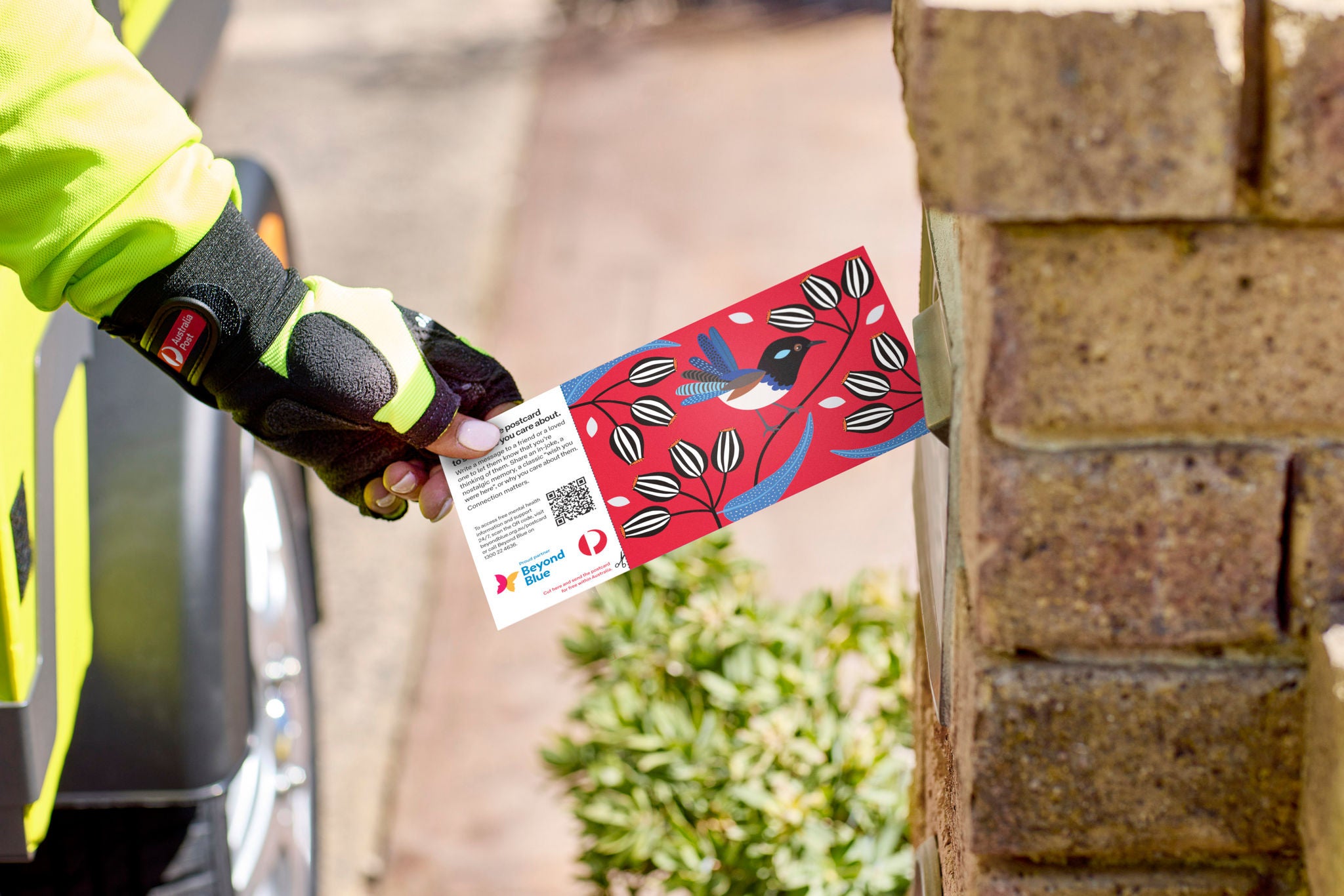 Postie inserting letter into letterbox