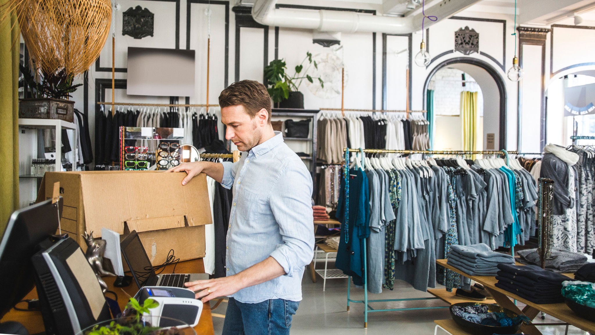 photo-man-standing-at-counter-in-clothing-store