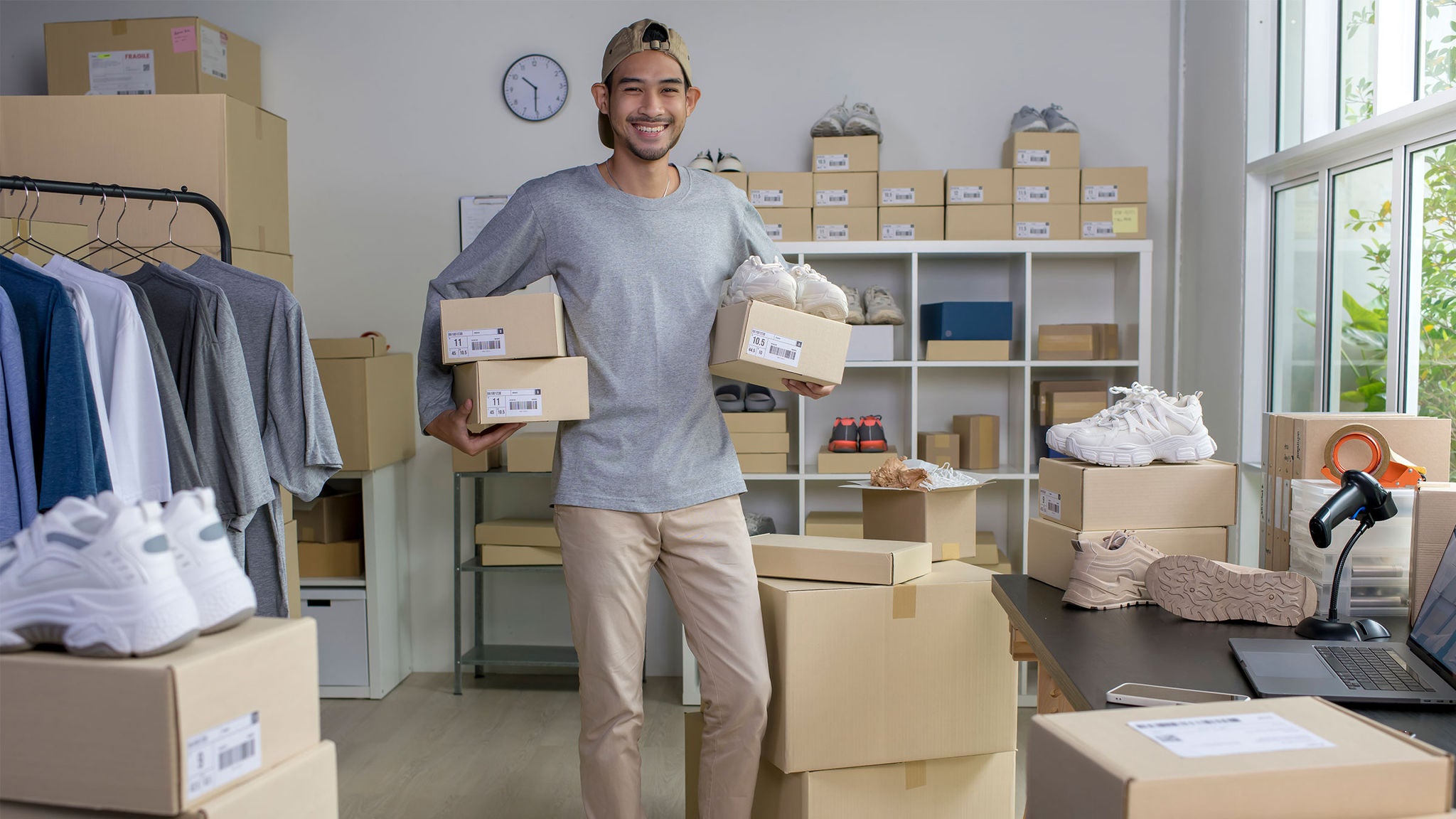 young-man-smiling-business-owner-holding-shoe-boxes-cap-beard