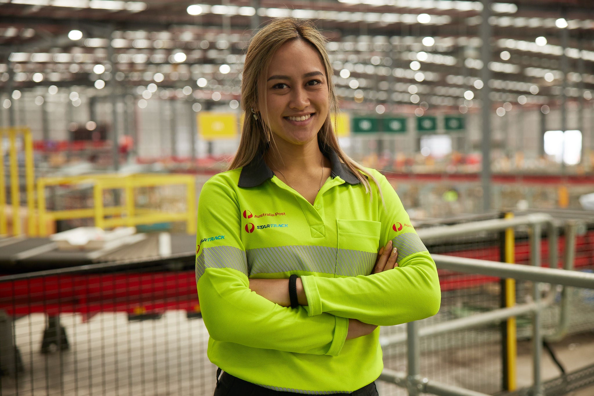 Woman standing with folded arms in a processing facility