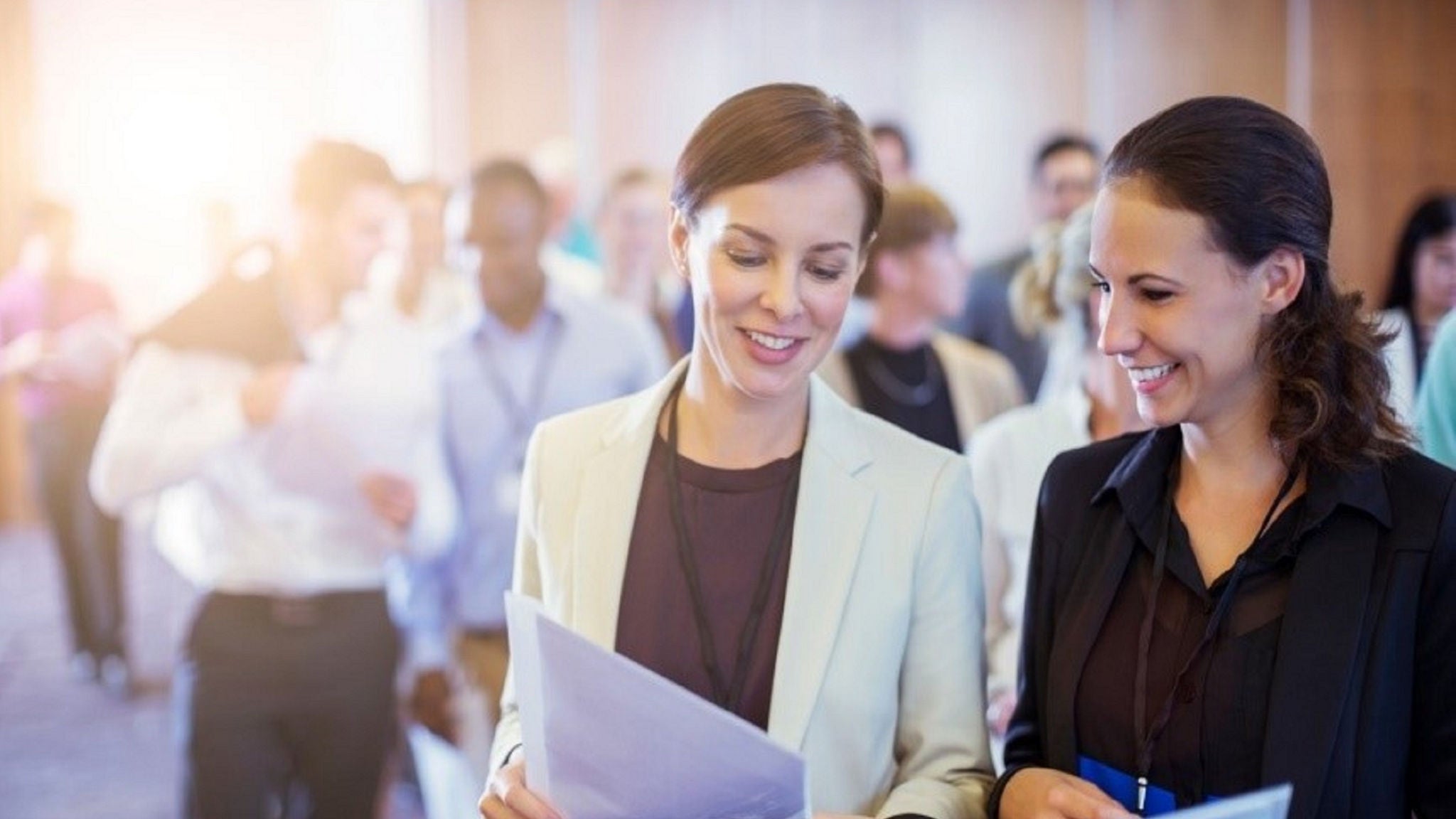Two woman looking at a document while smiling