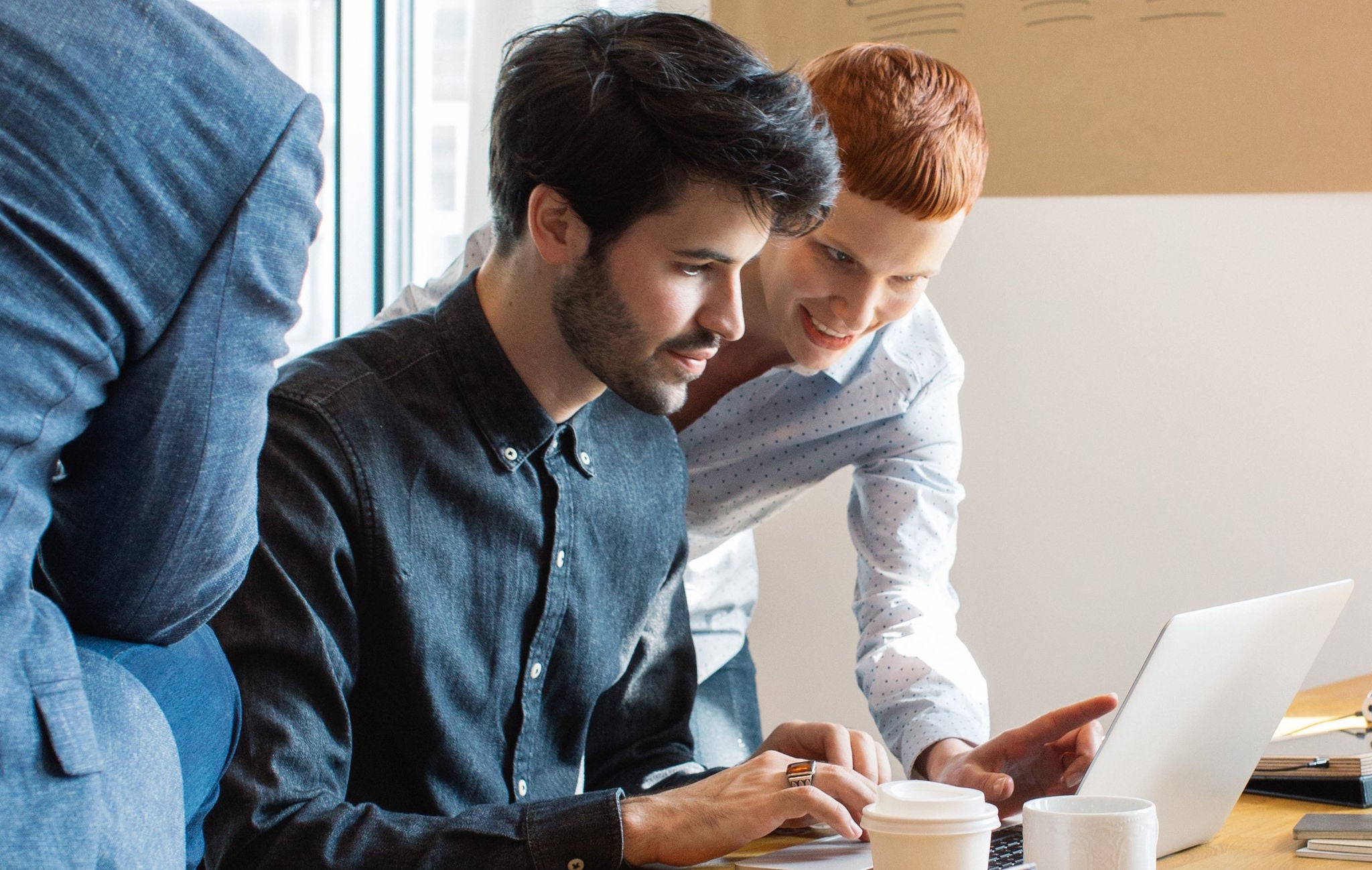 Man And Woman Working Together In Bright Office
