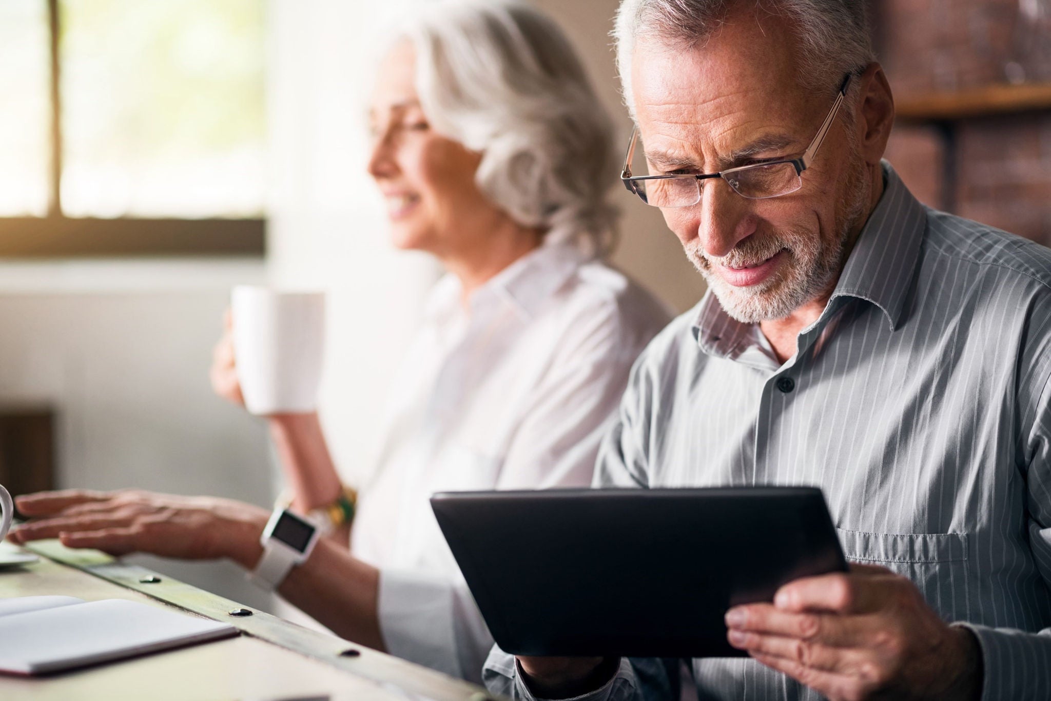 A lifestyle shot of an elderly man using a tablet